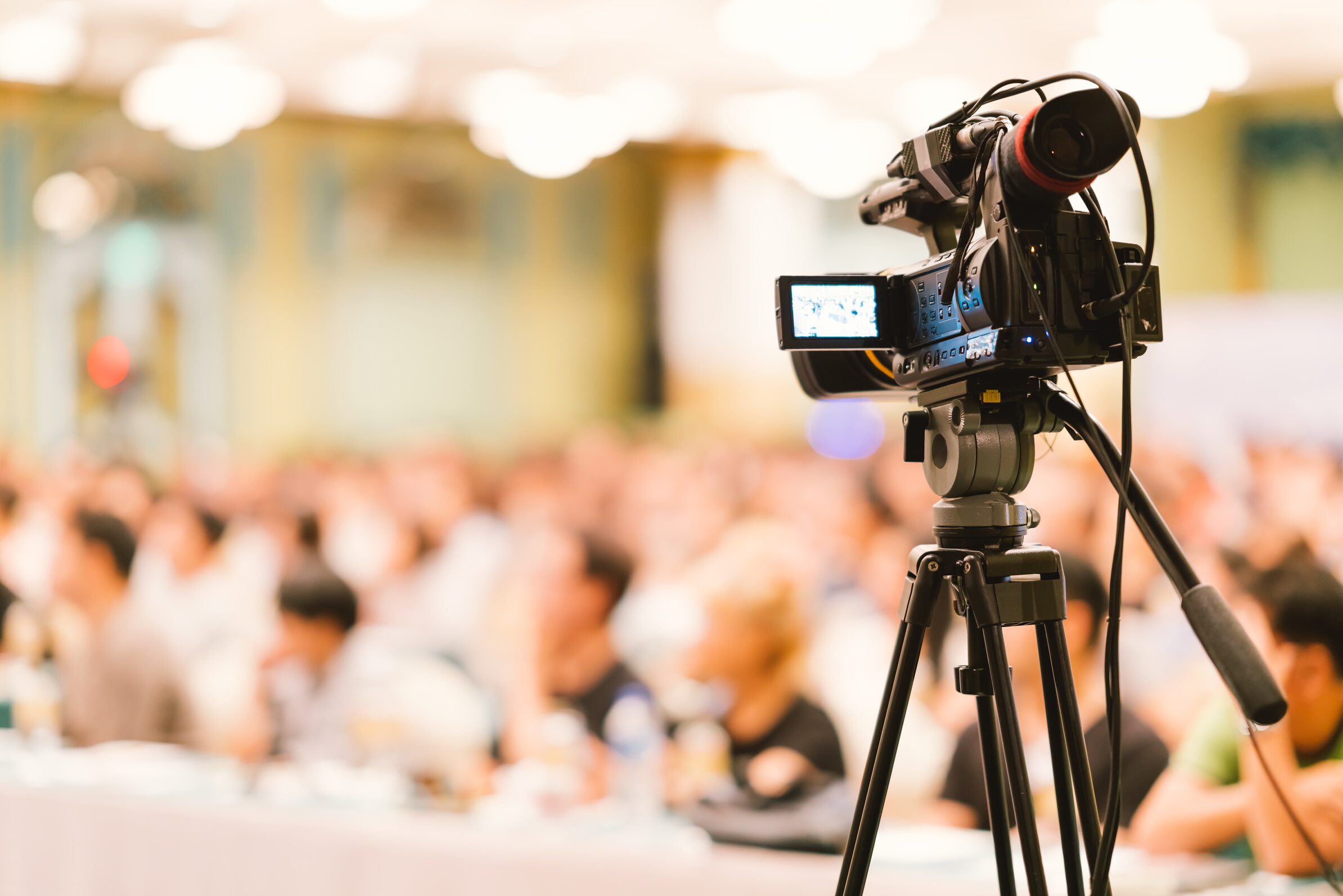 Video camera set record audience in conference hall seminar event. Company meeting, exhibition convention center, corporate announcement, public speaker, journalism industry, or news reporter concept